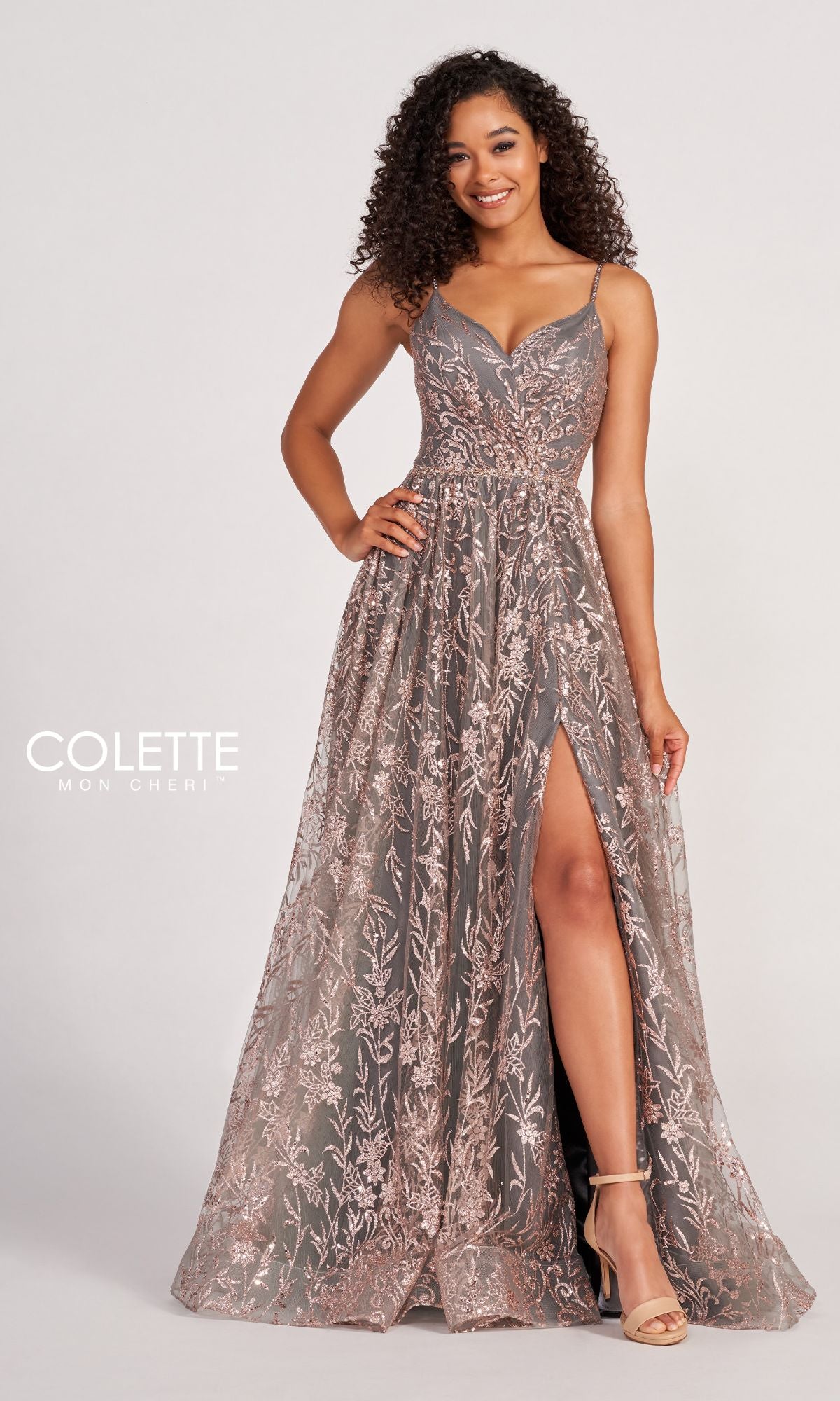 Woman wearing the Colette CL2022 Strappy A-Line Glitter Prom Dress, a floor-length gown with spaghetti straps and a thigh-high slit, elegantly posed against a plain background with the
